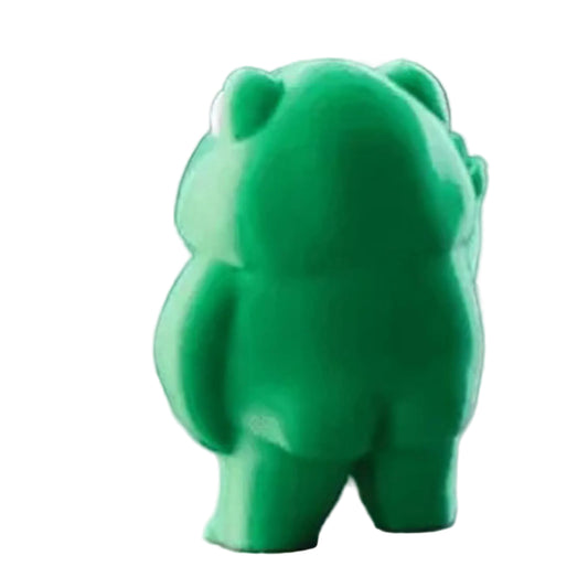 Green bear-shaped object on a textured surface with a blurred background